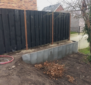 Zwarte schutting gemaakt van zwarte planken en bevestigd aan hardhouten palen. - Hoveniersbedrijf C.K. van Mourik de hovenier voor West Betuwe, Tiel, Culemborg, Geldermalsen, Buren