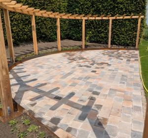 Grote plantenborder en pergola met kiwi's - Hoveniersbedrijf C.K. van Mourik de hovenier voor West Betuwe, Tiel, Culemborg, Geldermalsen, Buren