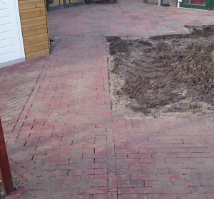 Bestratingspatroon met gebakken Dikformaten en Kaiserstones extra Ruby Black in wildverband. Diagonalen zorgen voor optische verbreding van de tuin. -Hoveniersbedrijf C.K. van Mourik-