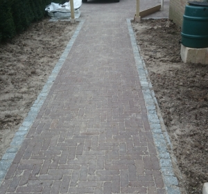 Bestrating Dikformaat met rand van porfierkeitjes en pergola van geimpregneerd Vurenhout - Hoveniersbedrijf C.K. van Mourik