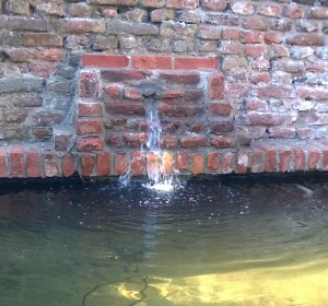 Gemetselde waterval tegen oude tuinmuur - Hoveniersbedrijf C.K. van Mourik